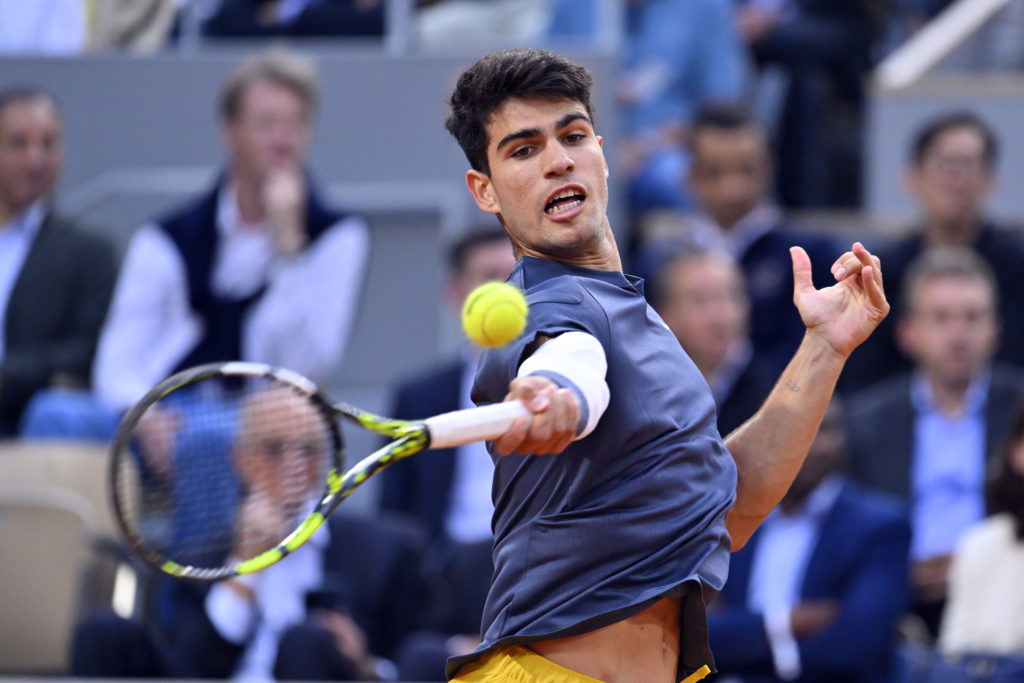 Carlos Alcaraz hits a forehand against Stefanos Tsitsipas at the 2024 French Open.