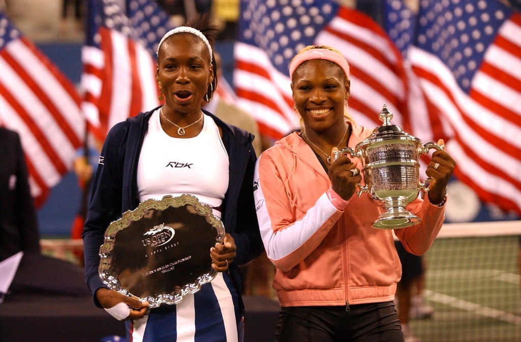 Venus and Serena Williams hold their trophies after the women's finals at US Open Tennis Championships