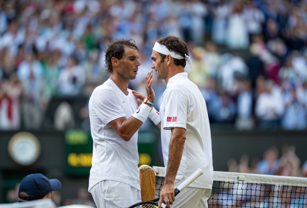 Roger Federer and Rafael Nadal meet at the net at Wimbledon in 2019.
