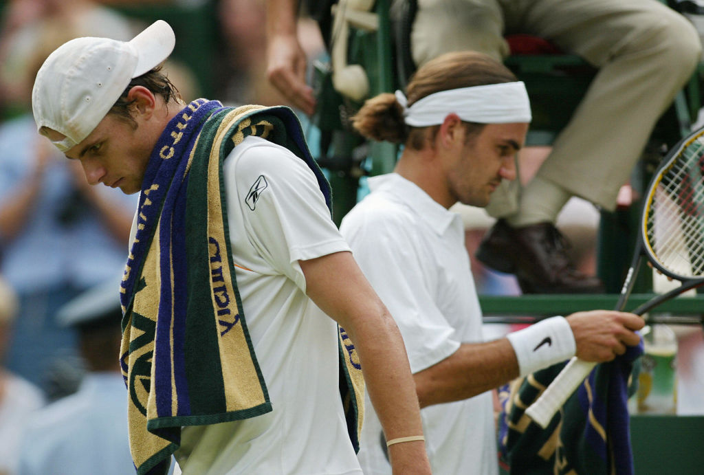 Andy Roddick (L) of the US walks past Ro