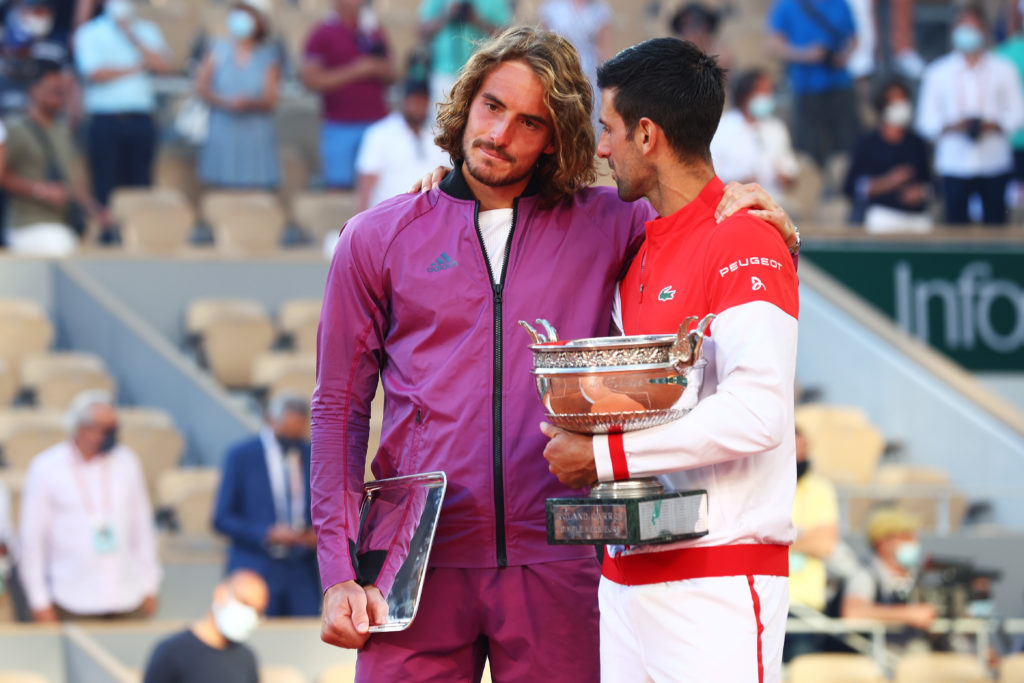 Stefanos Tsistipas and Novak Djokovic hold their trophies after the 2021 French Open final