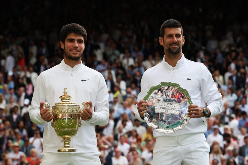 Carlos Alcaraz and Novak Djokovic holding their trophies after the 2023 Wimbledon final.