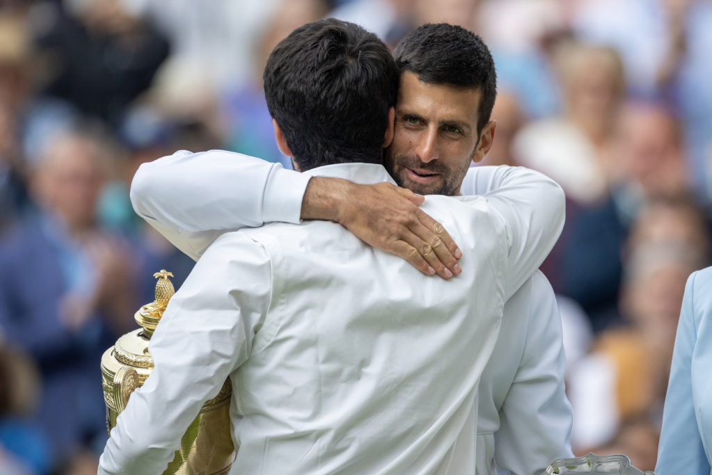 Novak Djokovic hugging Carlos Alcaraz at Wimbledon 2023.