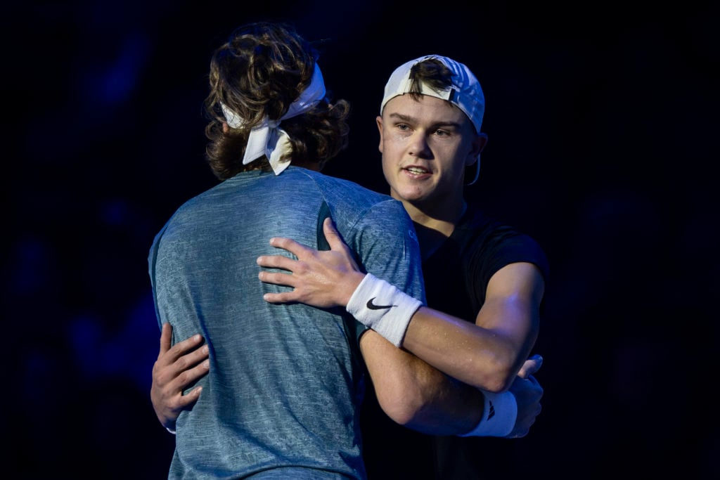 Holger Rune (R) of Denmark hugs Stefanos Tsitsipas of Greece