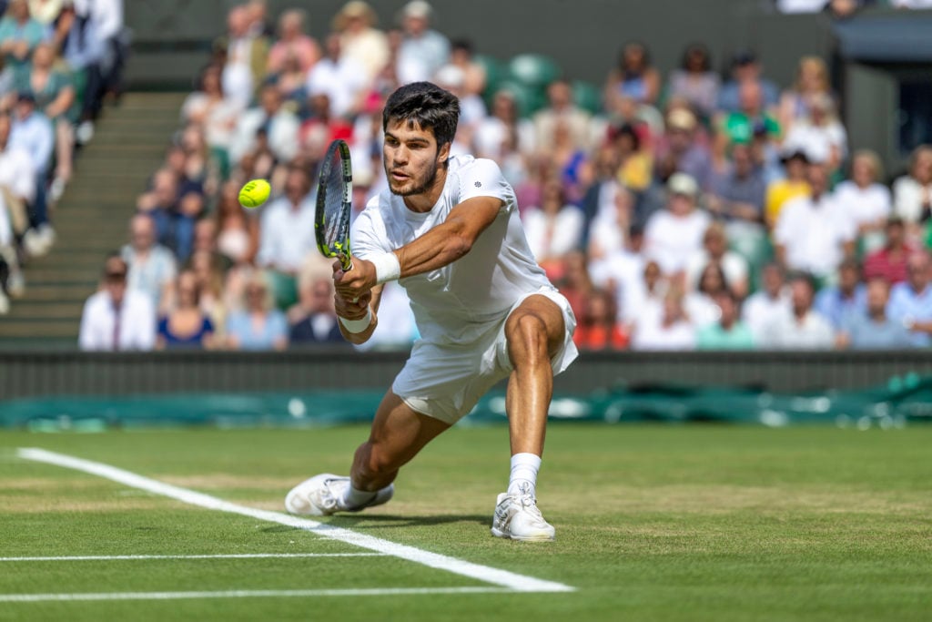 Carlos Alcaraz hits a backhand during the Wimbledon 2023 final.