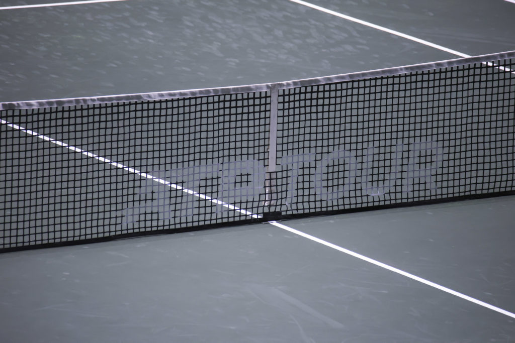 Close up at the net of a tennis court with the ATP TOUR inscription.