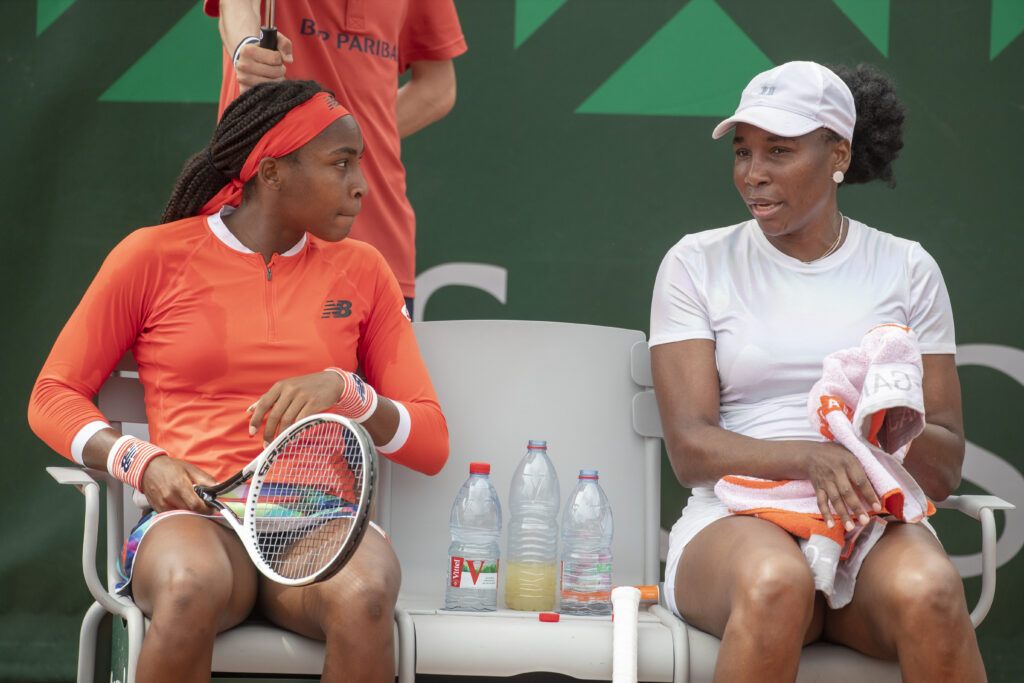 Venus Williams and Coco Gauff sit down during a changeover at the 2021 French Open