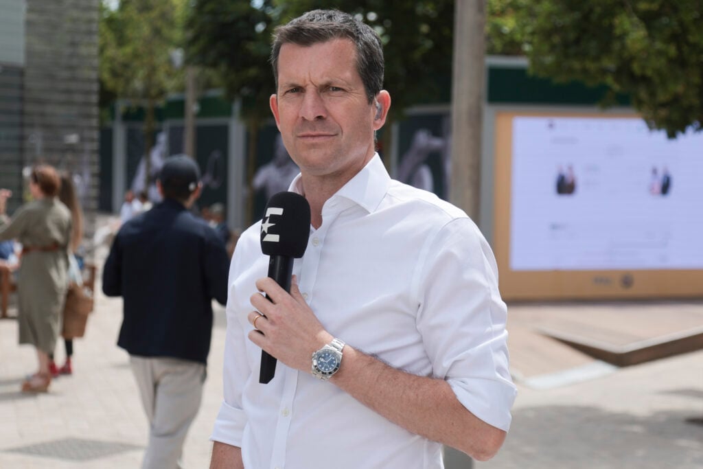 Tim Henman holds a microphone on the final day of the 2024 French Open