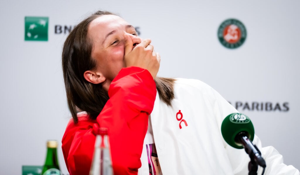 Iga Swiatek laughs during her post-match press conference at the 2025 French Open