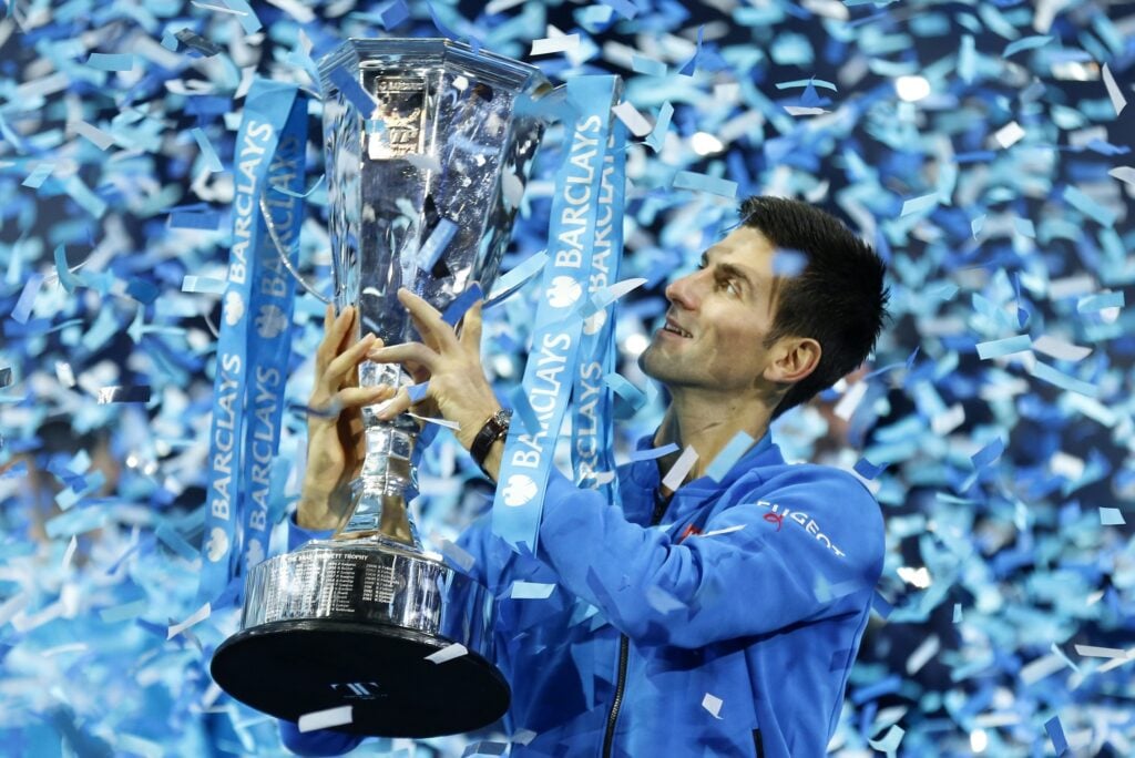 Novak Djokovic celebrates with the trophy after beating Roger Federer in the final of the 2015 ATP Finals