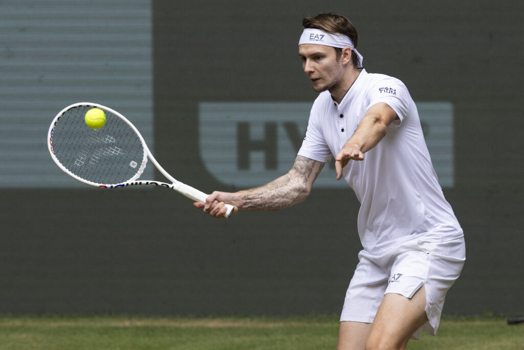 Alexander Bublik hits a forehand against Jannik Sinner at the 2023 Halle Open