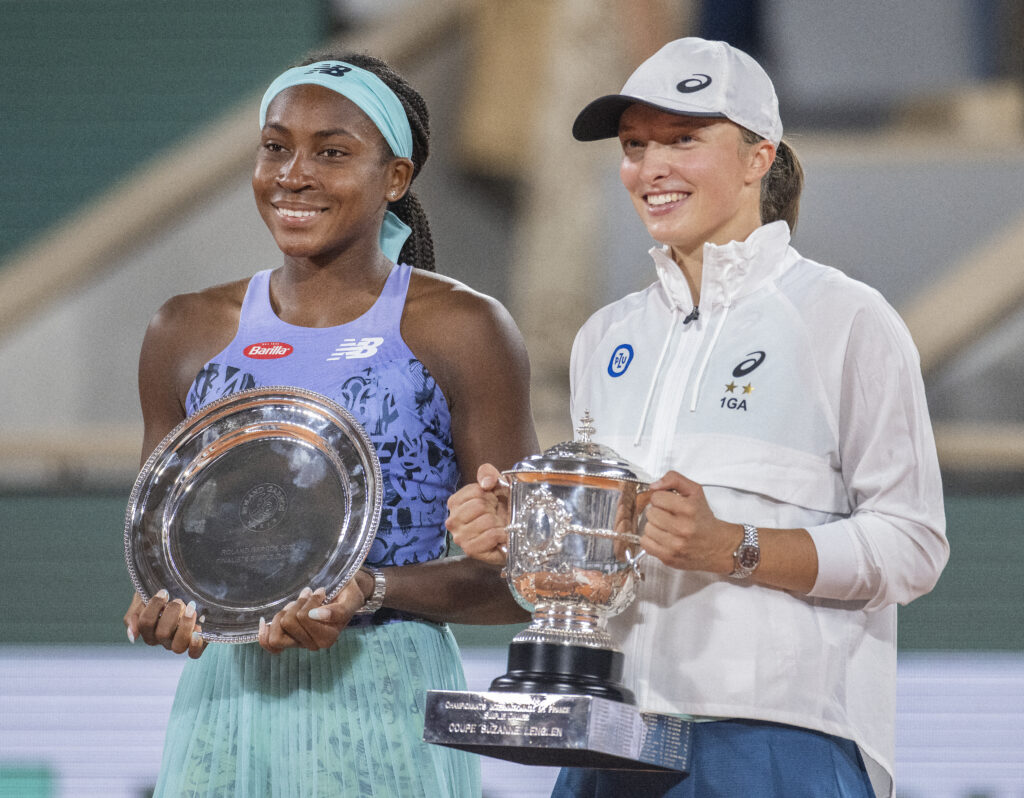 Coco Gauff and Iga Swiatek hold their trophies after the 2022 French Open final.