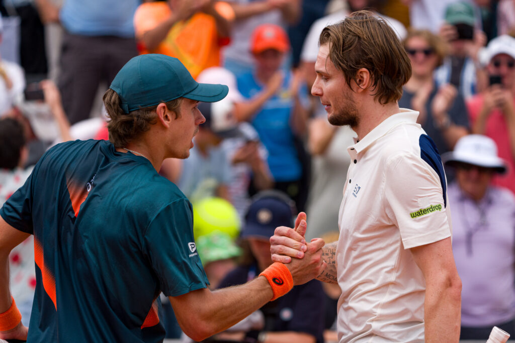 Alex de Minaur and Alexander Bublik embrace at the net after their 2025 French Open match