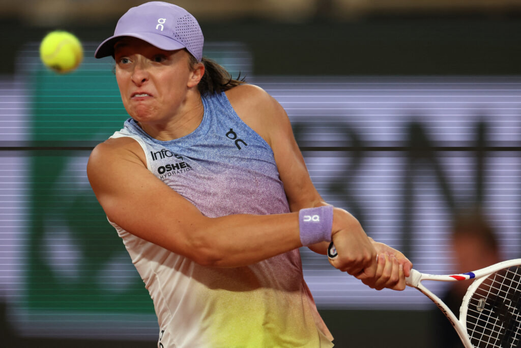 Iga Swiatek hits a backhand against Aryna Sabalenka at the 2025 French Open