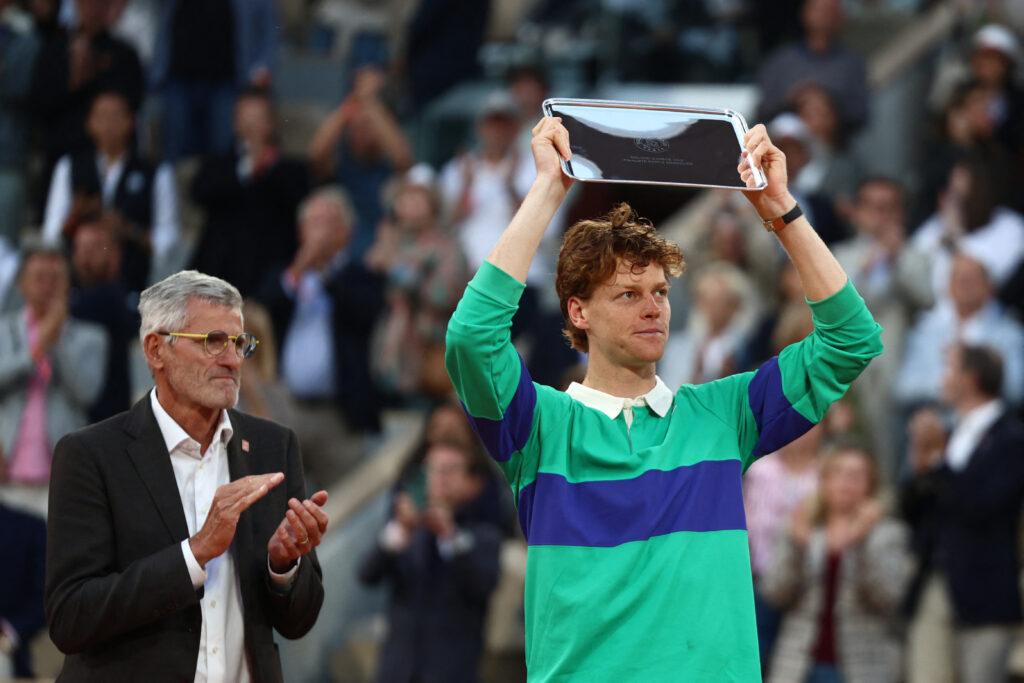 Italy's Jannik Sinner (R) holds up his trophy, past French Tennis Federation's President Gilles Moretton, after loosing his men's singles final match against Spain's Carlos Alcaraz on day 15 of the French Open tennis tournament on Court Philippe-Chatrier at the Roland-Garros Complex in Paris on June 8, 2025.