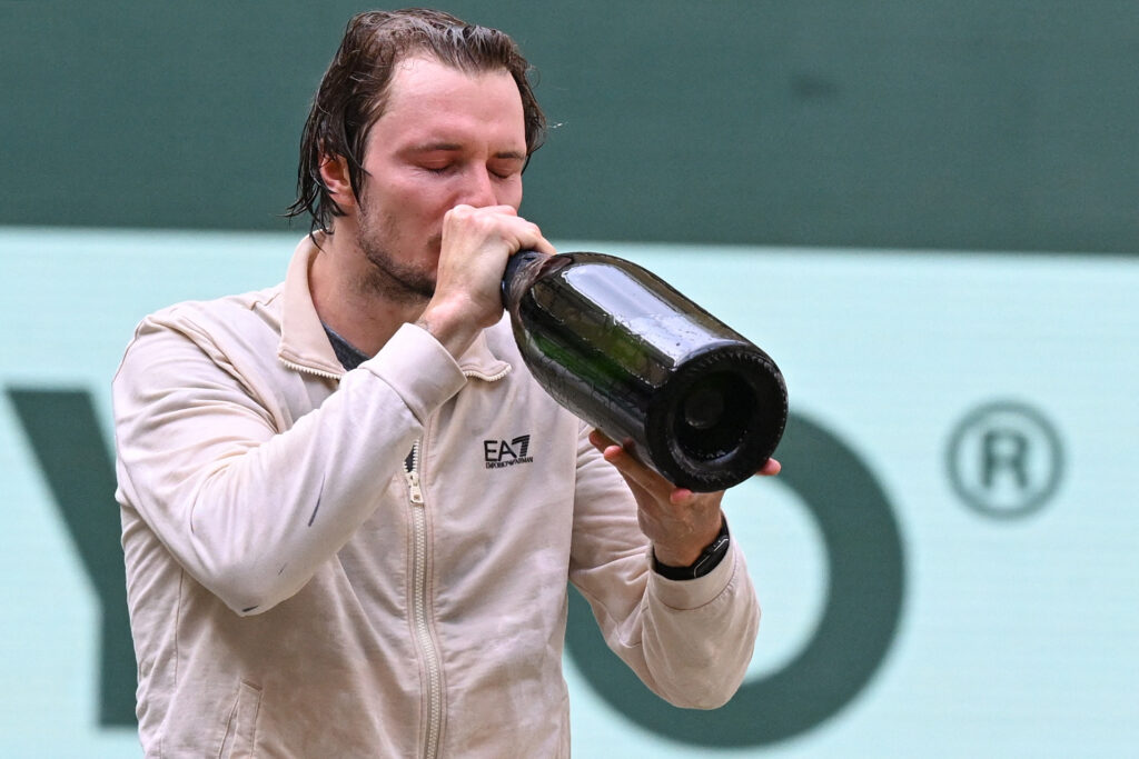 Alexander Bublik drinks champagne after winning the 2025 Halle Open