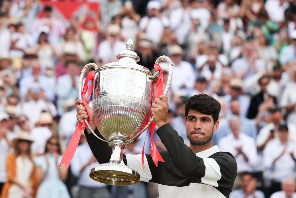 Carlos Alcaraz lifts the Queen's title in 2025.