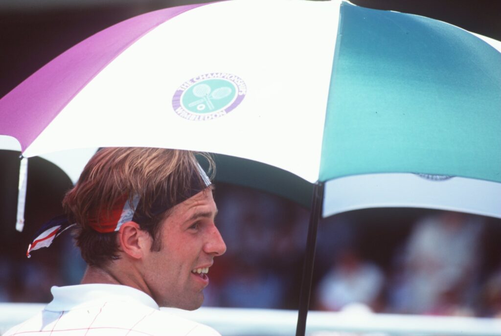 Greg Rusedski sat under an umbrella during his third round match at Wimbledon in 1995 against Oliver Delaitre.
