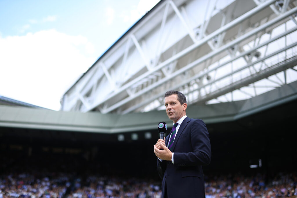 Tim Henman holds a microphone at Wimbledon