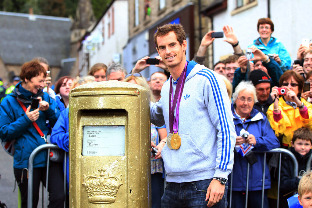 Andy Murray stands next to his golden post box in Scotland.
