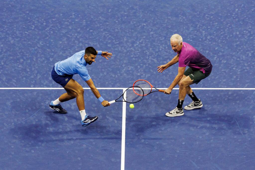 John McEnroe and Novak Djokovic go to hit a ball
