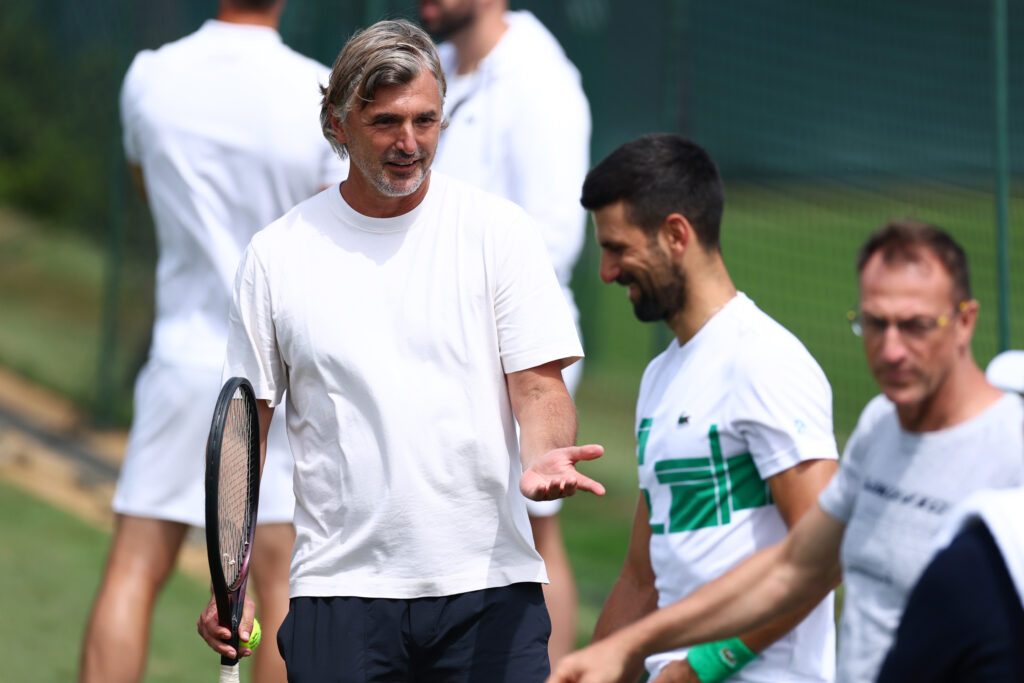 Goran Ivanisevic speaks to Novak Djokovic on the practice courts at Wimbledon