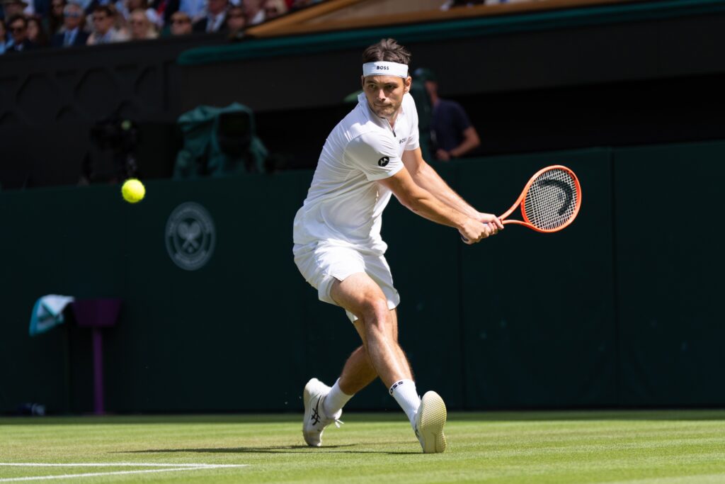Taylor Fritz plays a backhand during his Wimbledon Championships third round match