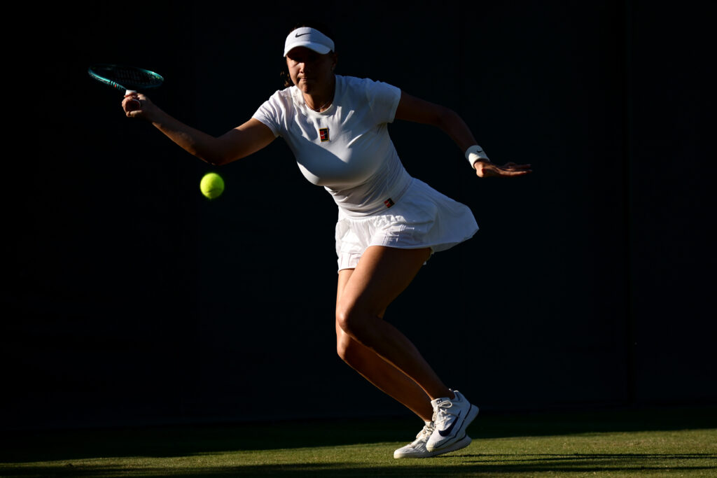 Amanda Anisimova of United States plays a forehand against Yulia Putintseva of Kazakhstan during the during the Ladies' Singles First match on day one of The Championships Wimbledon 2025 at All England Lawn Tennis and Croquet Club.