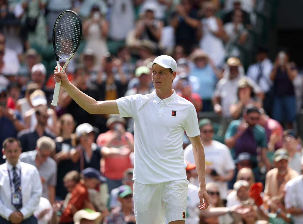 Jannik Sinner lifts his racket in appreciation