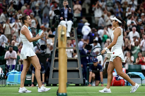 Aryna Sabalenka and Emma Raducanu approach the net to shake hands after their match at Wimbledon.