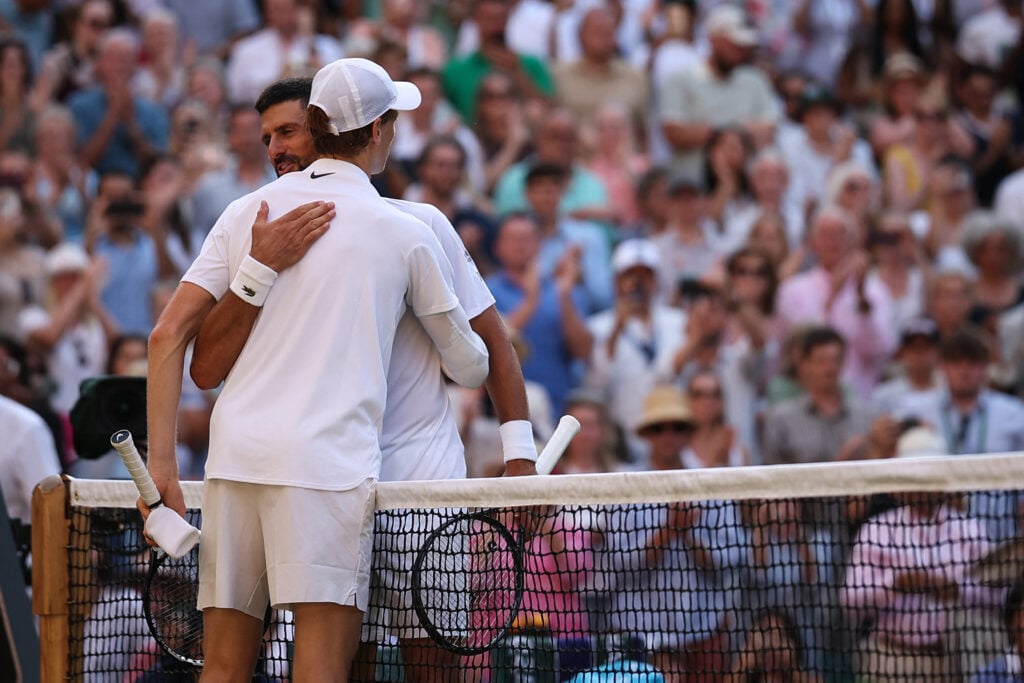 Novak Djokovic and Jannik Sinner embrace at the net after their 2025 Wimbledon semifinal