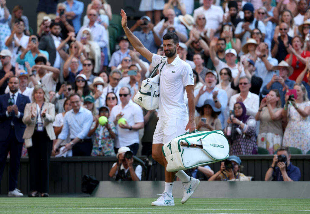 Novak Djokovic exits Centre Court at Wimbledon following his loss to Jannik Sinner.
