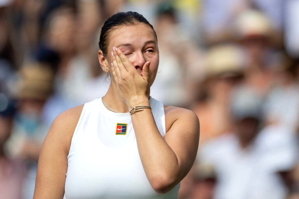 Amanda Anisimova wipes away tears after her defeat to Iga Swiatek at the 2025 Wimbledon Championships.
