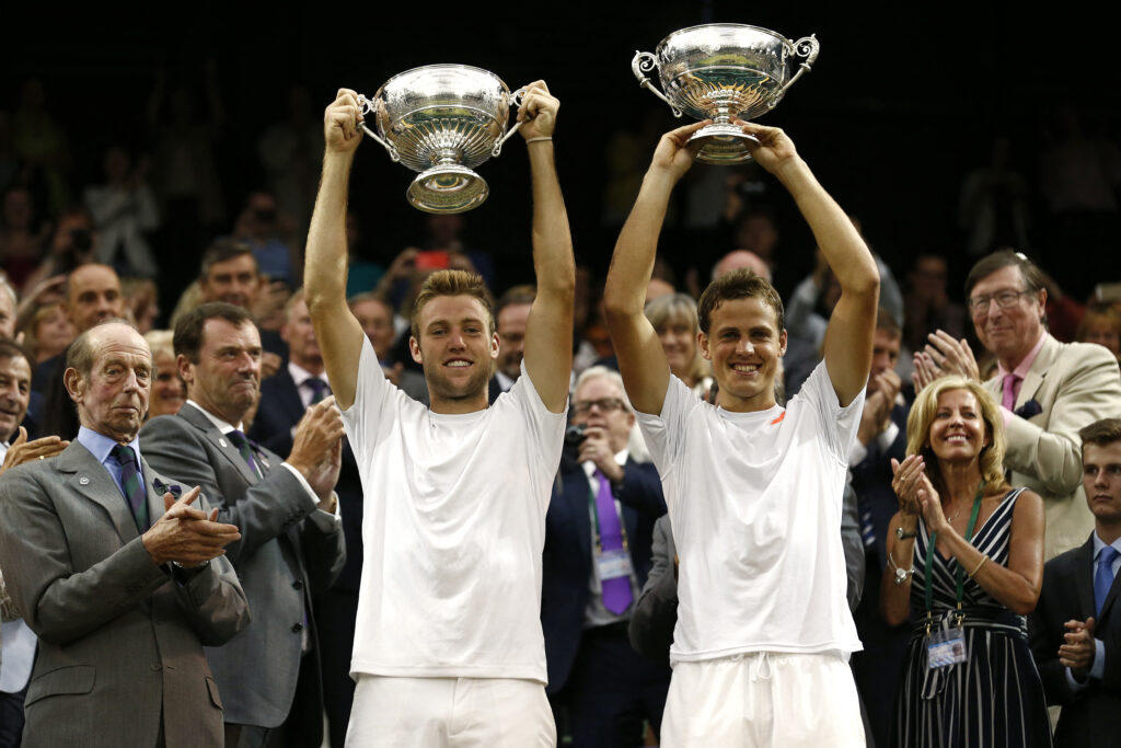Vasek Pospisil and Jack Sock lift their Wimbledon trophies
