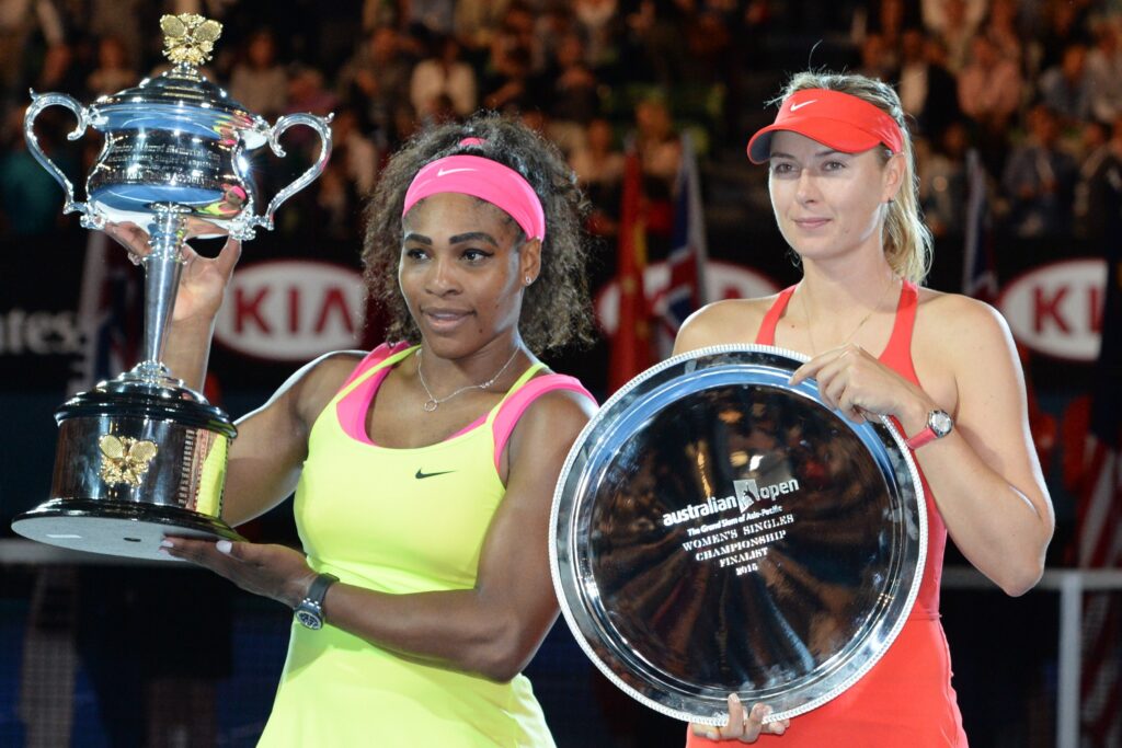Serena Williams and Maria Sharapova hold up the winners and runner-up trophies at the 2015 Australian Open