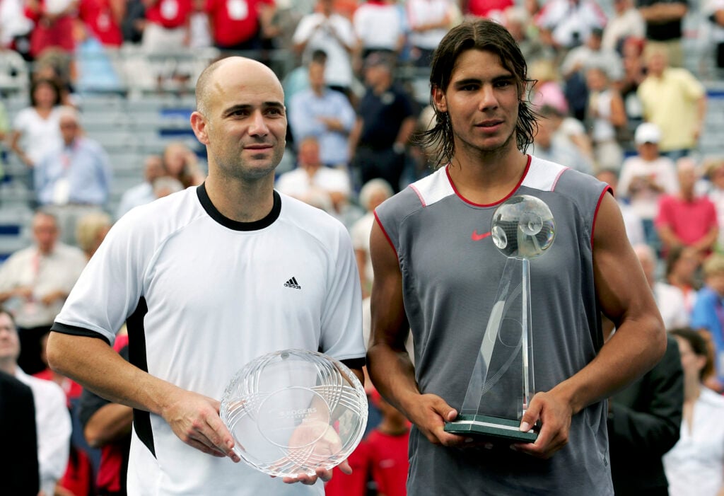Andre Agassi and Rafael Nadal holding their trophies after the Canadian Open final.