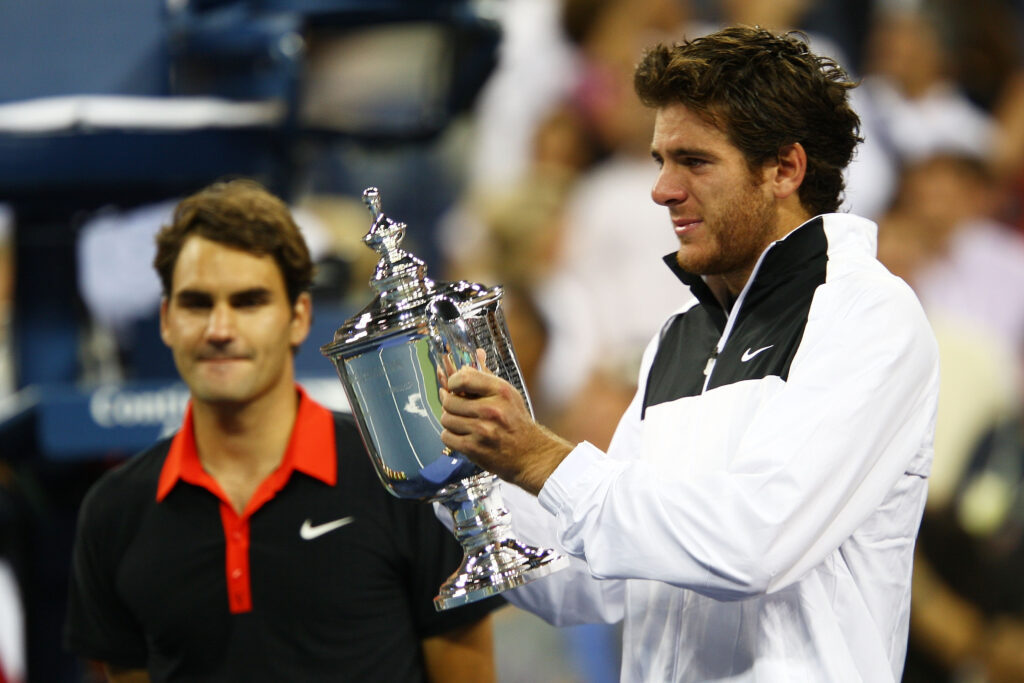 Roger Federer looks on as Juan Martin Del Potro holds the 2009 US Open title.
