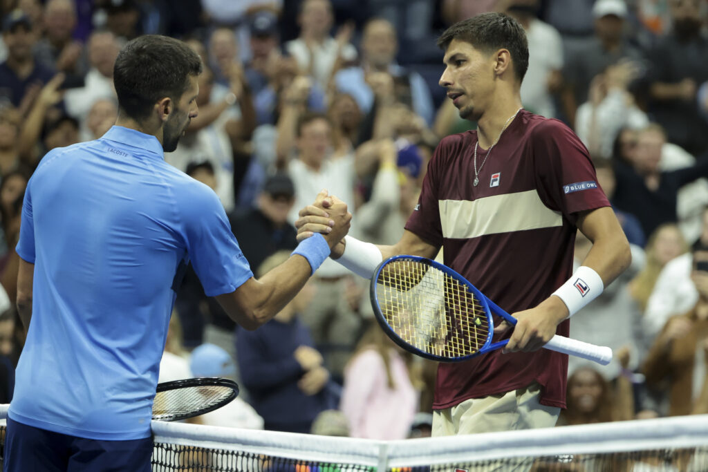 Alexei Popyrin and Novak Djokovic shake hands after their 2024 US Open clash.