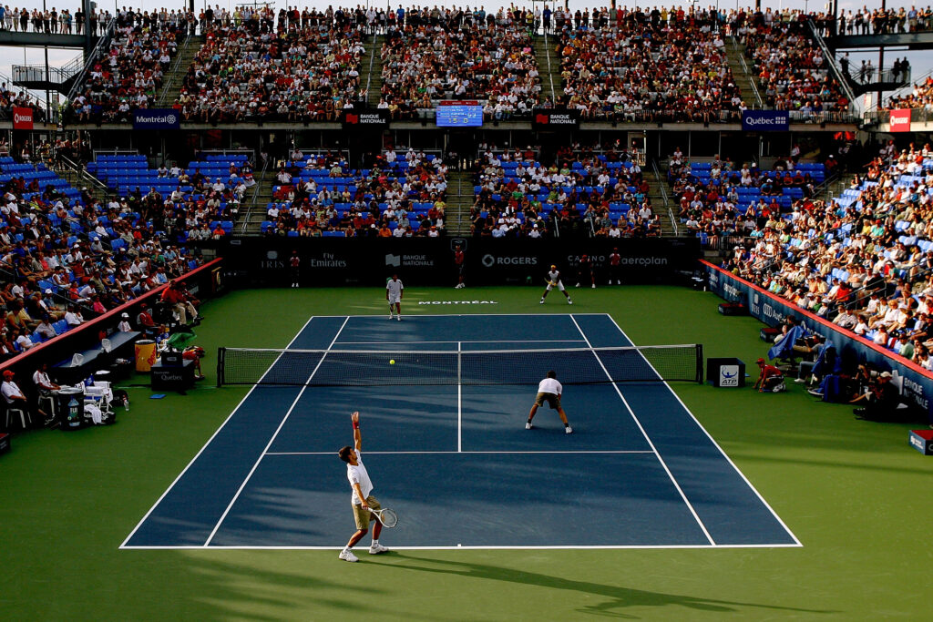 Novak Djokovic of Servia serves to Francisco Roig and Rafael Nadal of Spain while playing with Dusan Vemic of Serbia during the Rogers Cup at Uniprix Stadium.