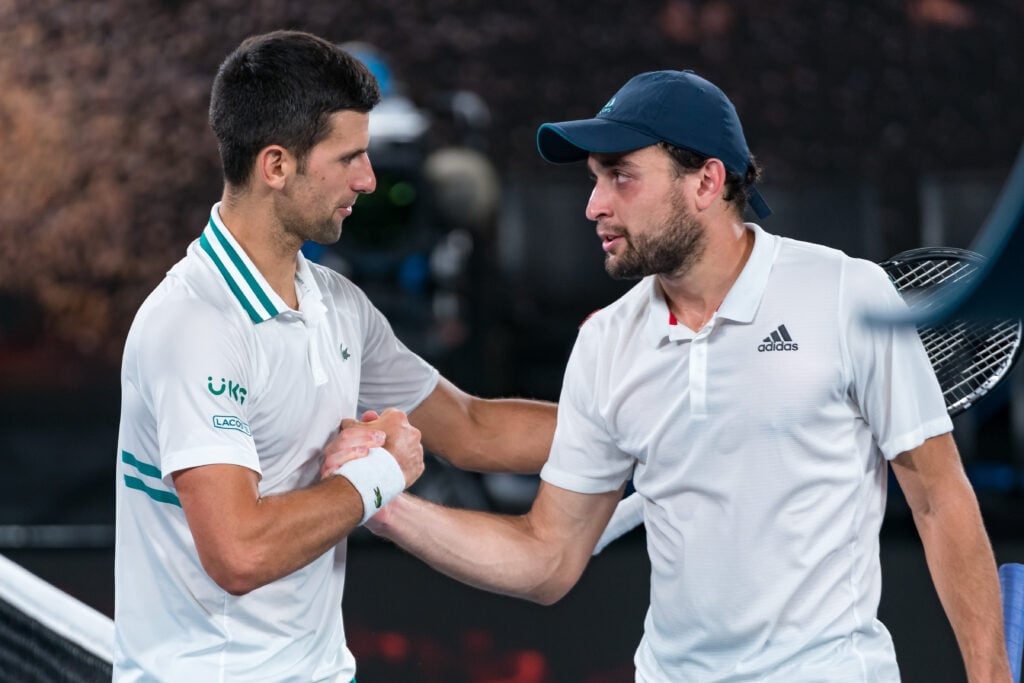 Novak Djokovic of Serbia shakes hands with Aslan Karatsev of Russia following Djokovic's victory in their Men’s Singles Semifinals match during day 11 of the 2021 Australian Open at Melbourne Park.