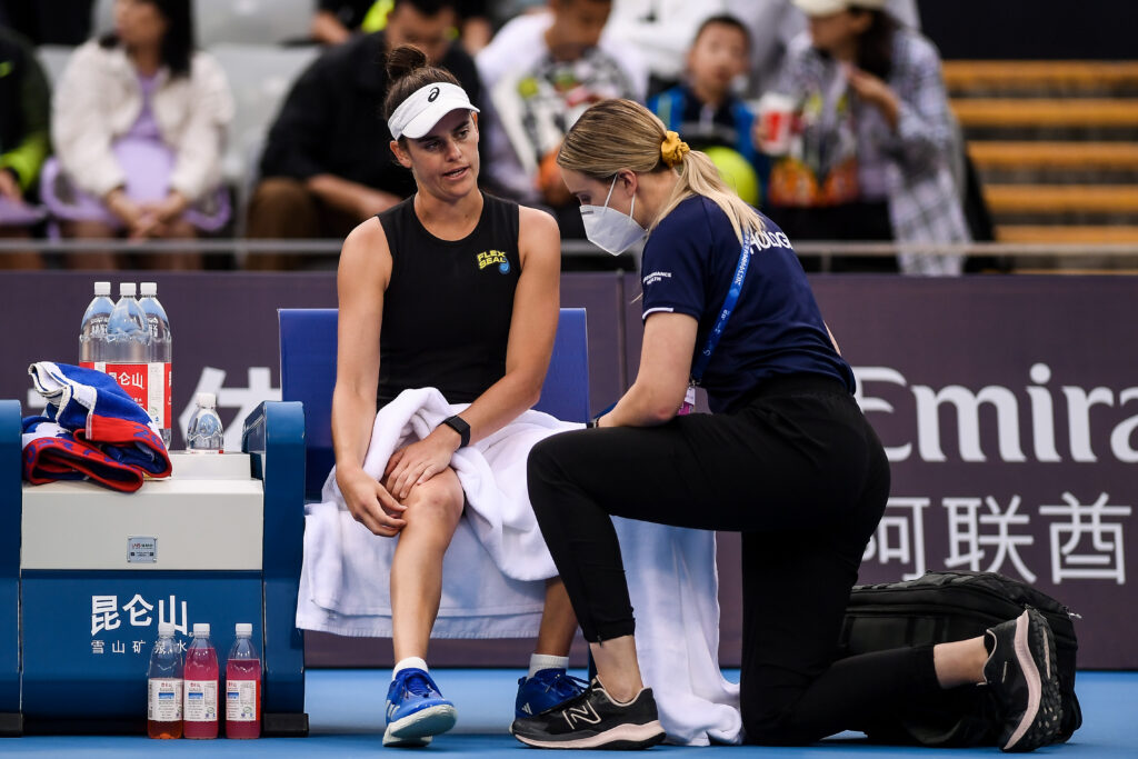Jennifer Brady of United States is treated for an injury in the Women's Singles Round of 32 match against Magda Linette of Poland on day seven of 2023 China Open at the National Tennis Center.