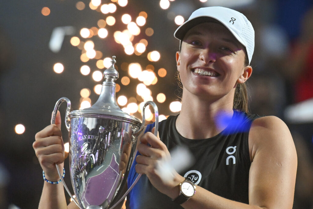 Iga Swiatek celebrates with the WTA Finals trophy in 2023