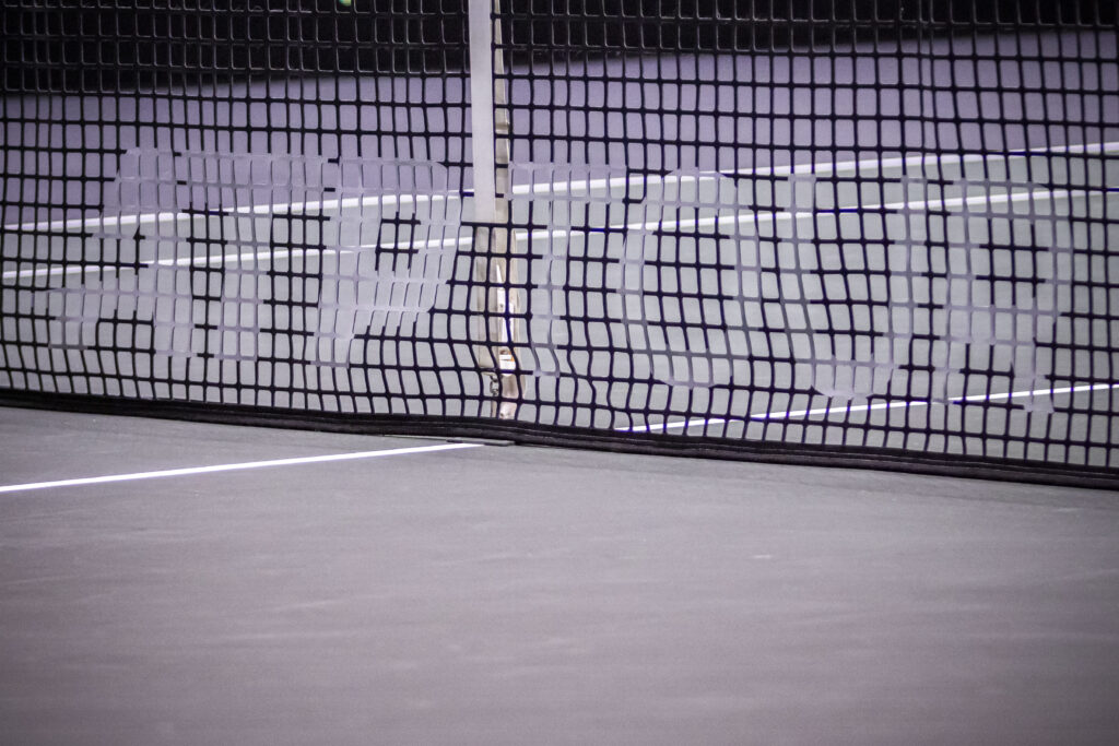 The ATP TOUR logo inscription in the net of the tennis court.