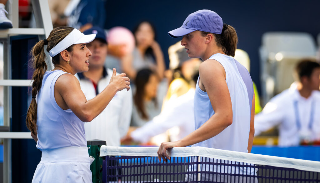 Camila Osorio of Colombia and Iga Swiatek of Poland meet at the net after Osorio's injury retirement from the third round on Day 8 of the China Open at National Tennis Center.
