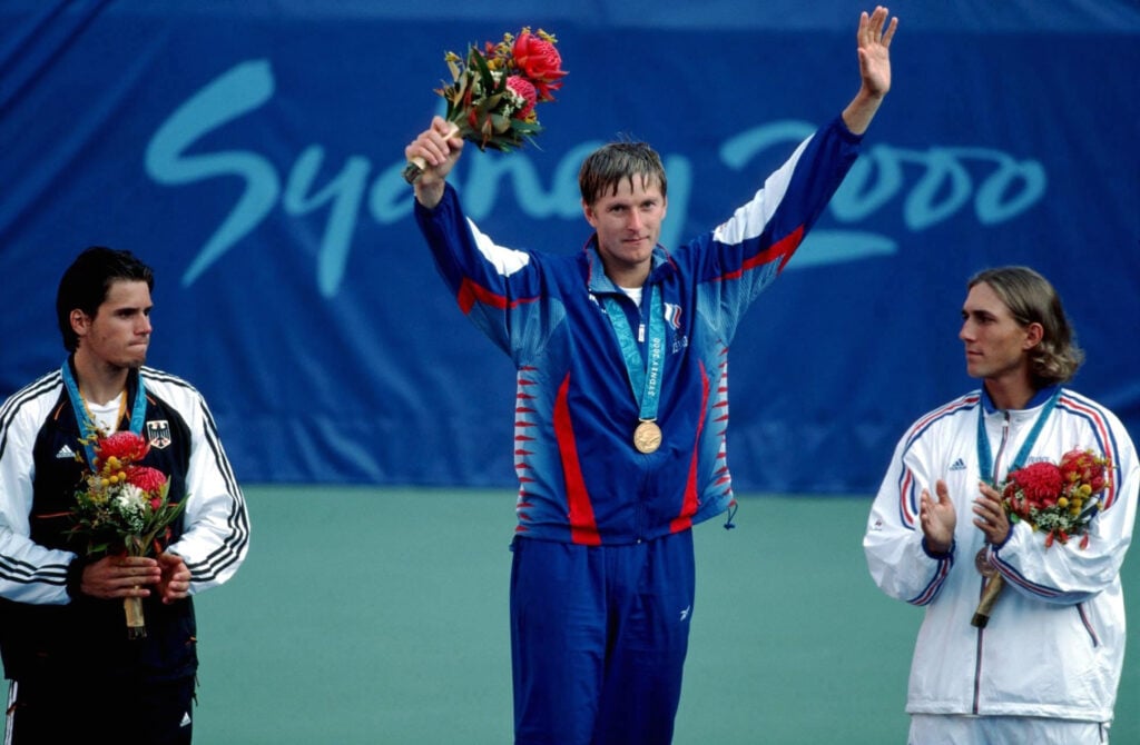 Yevgeny Kafelnikov of Russia stands on the podium wearing his gold medal after winning the tennis singles event at the Sydney Olympics in 2000.