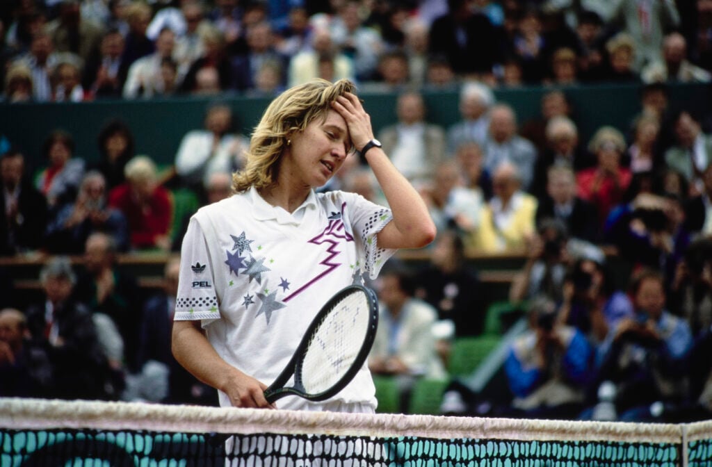 Steffi Graf, her left hand held to her head, during a Women's Singles match at the French Open at Stade Roland Garros in Paris, France, May 1988. Graf won the '88 Women's Singles title, beating Belarusian tennis player Natasha Zvereva.