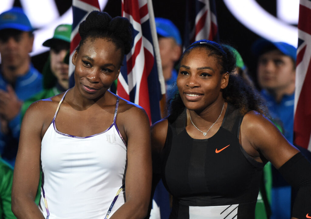 Serena Williams of the US stands with runner up Venus Williams of the US at the start of the awards ceremony for the women's singles final on day 13 of the Australian Open tennis tournament.