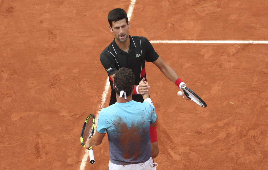 Novak Djokovic shakes hands with Marco Cecchinato after losing French Open quarterfinal