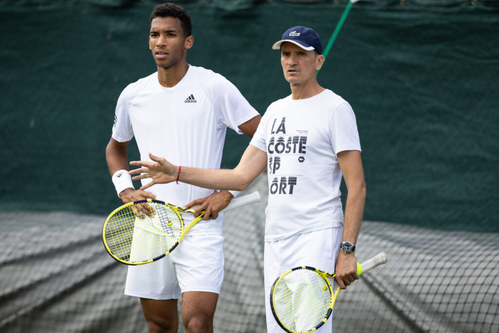 Felix Auger-Aliassime of Canada with his coach Frederic Fontang during practice at The Wimbledon Championships in 2022.
