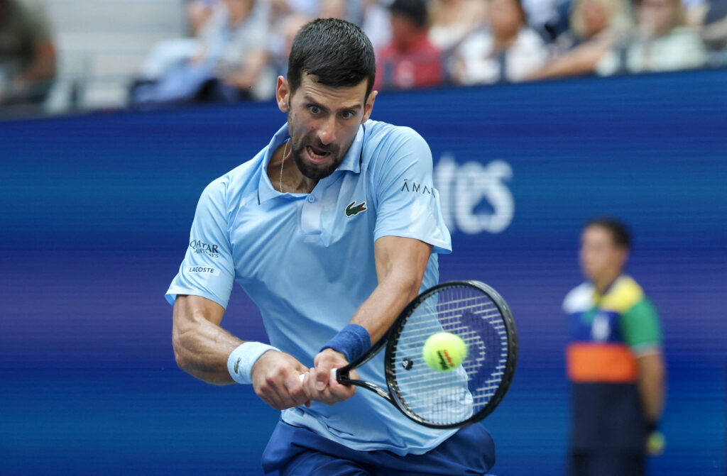 Novak Djokovic plays a backhand return against Carlos Alcaraz in the semifinals of the US Open.